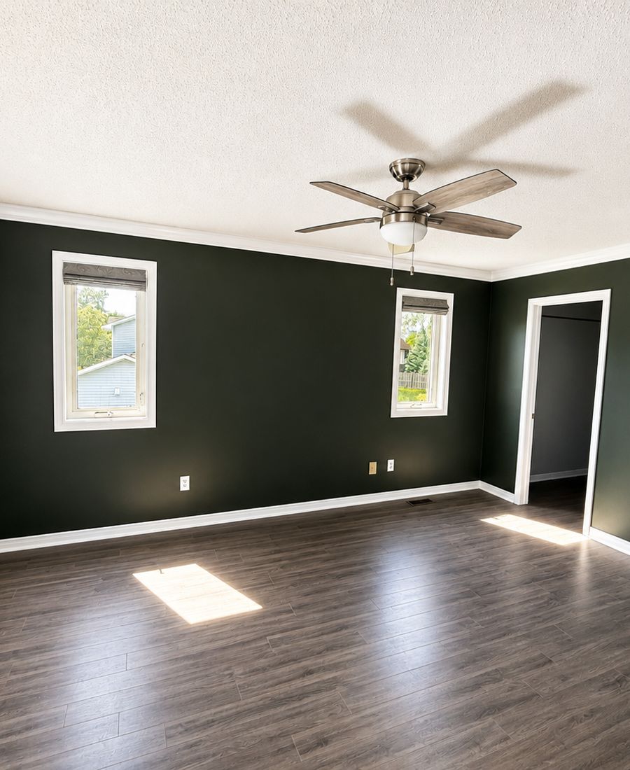 Freshly painted bedroom with deep green walls, white trim, and ceiling fan in Gloucester