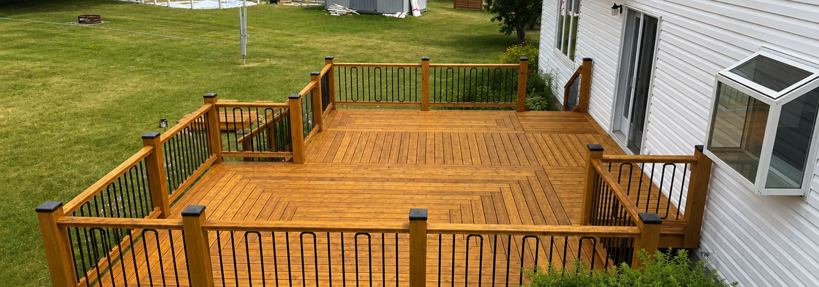 Freshly stained Ottawa backyard deck with honey-brown finish and black aluminum railings
