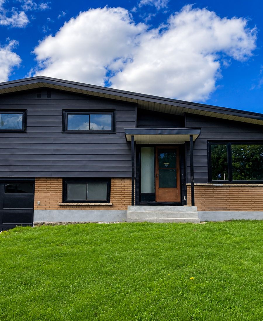 Two-story home exterior freshly painted with refreshed siding, trim, and front door in Orléans
