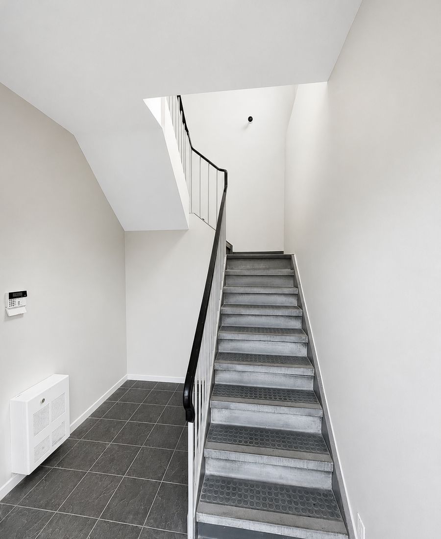 Refinished staircase with black painted railings, white spindles, and clean modern risers in Ottawa