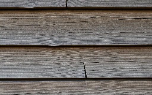 Weathered wood siding showing cracking and wear