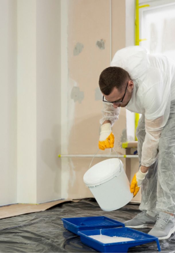 Man pouring paint into a paint tray